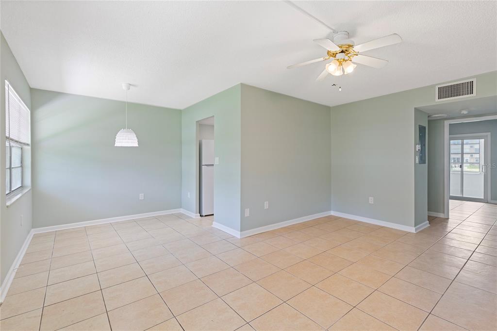 An empty room with light green walls, beige tile flooring, and a ceiling fan — 1051 79TH AVENUE N UNIT 103, ST PETERSBURG, FL