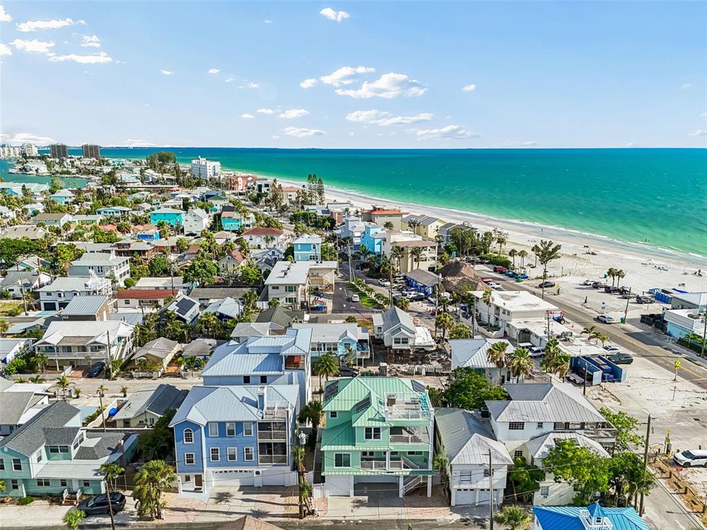 An aerial view shows colorful beach houses near the ocean with a sandy shoreline — 111 91ST AVENUE, TREASURE ISLAND, FL