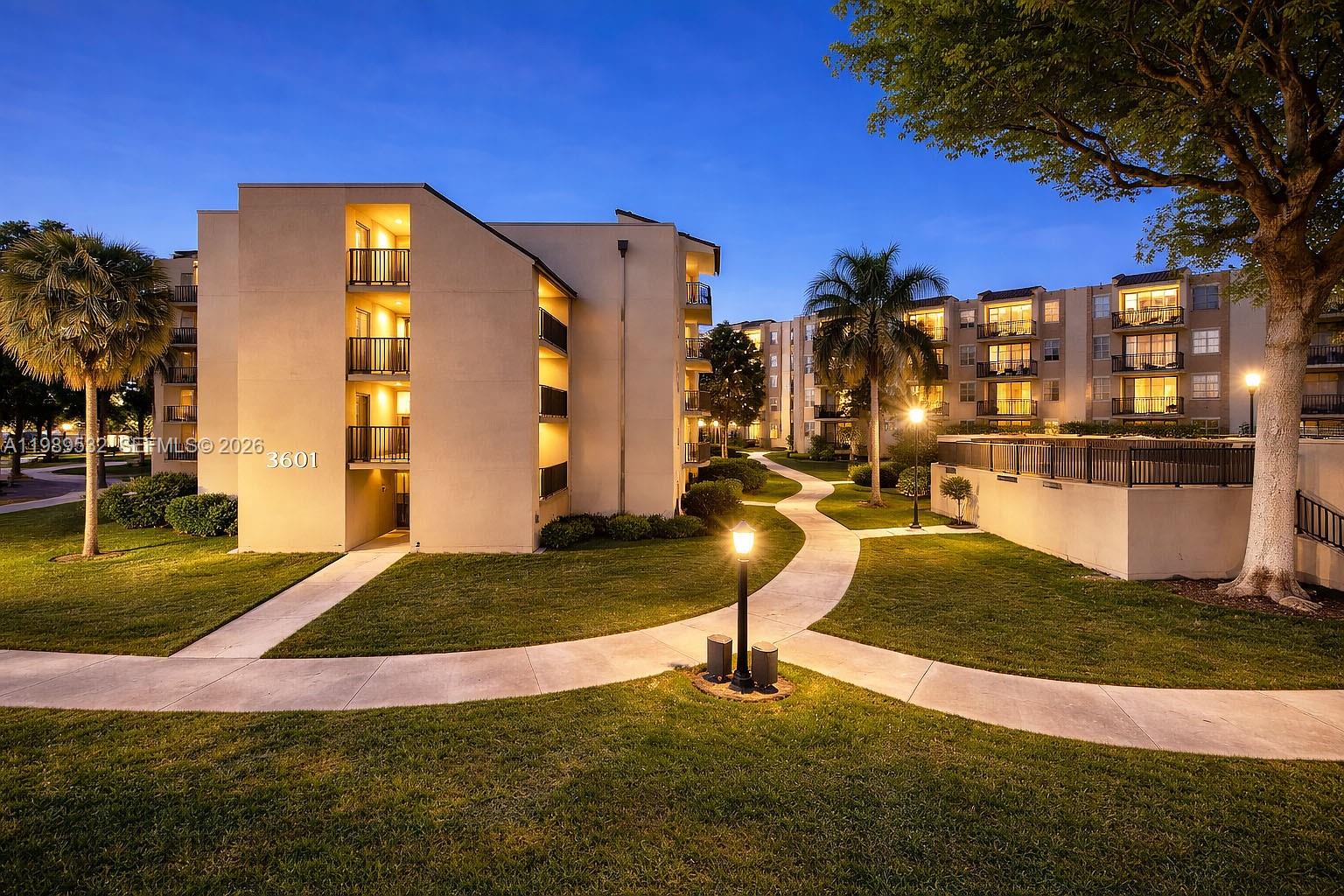 An exterior view of a multi-story apartment complex with landscaped grounds and paved walkways — 3581 SW 117th Ave # 308, Miami FL 33175, MIAMI, FL