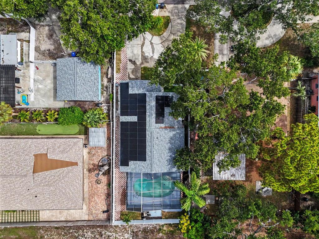 An aerial view shows a house with solar panels, a screened pool, and surrounding trees — 8170 22ND AVENUE N, ST PETERSBURG, FL