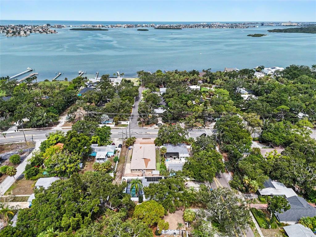 An aerial view shows a residential property surrounded by trees near a large body of water — 8170 22ND AVENUE N, ST PETERSBURG, FL