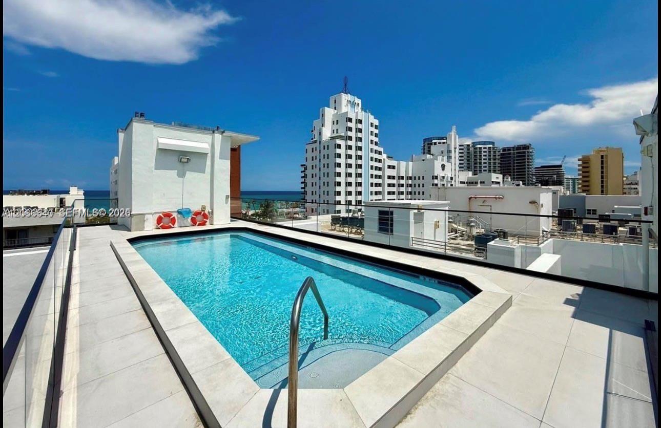 A rooftop swimming pool with a glass railing overlooking a city skyline and the ocean — 4122 Collins Ave # 6A, Miami Beach FL 33140, MIAMI BEACH, FL