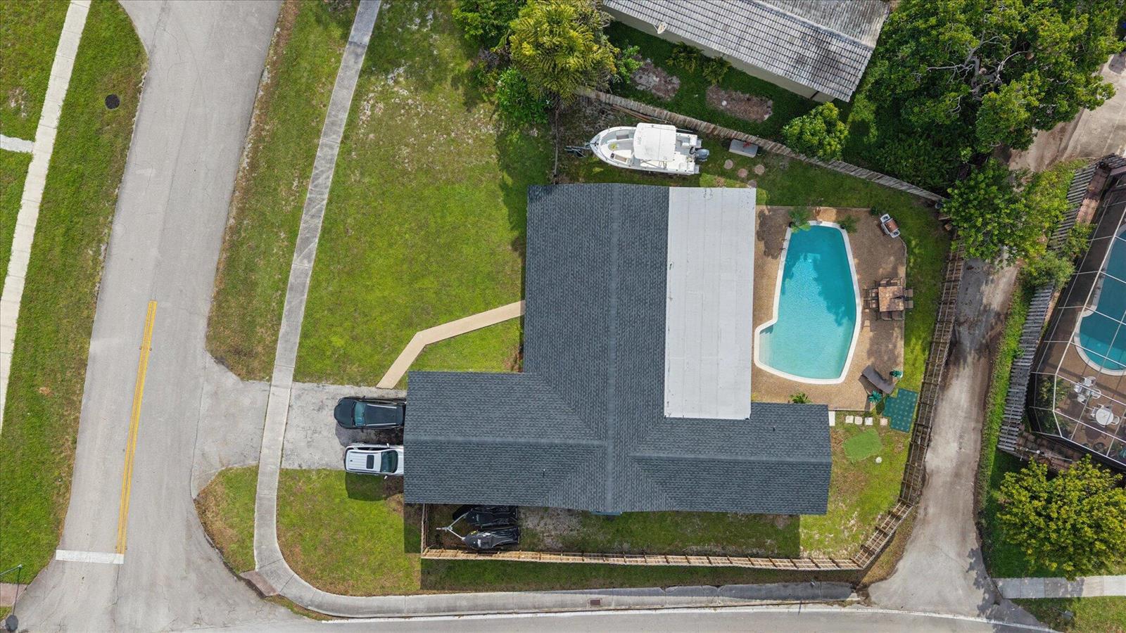 An aerial view shows a house with a dark roof, a pool, and parked vehicles — 4601 W Hawthorne Circle, Hollywood FL 33021, HOLLYWOOD, FL