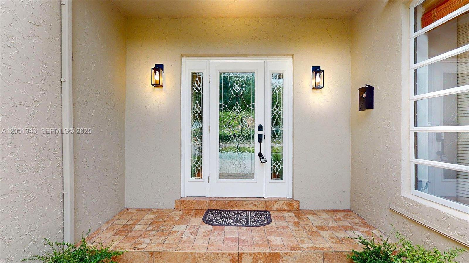The front entrance features a white door with decorative glass panels and two wall sconces — 10251 SW 80th St # 0, Miami FL 33173, MIAMI, FL