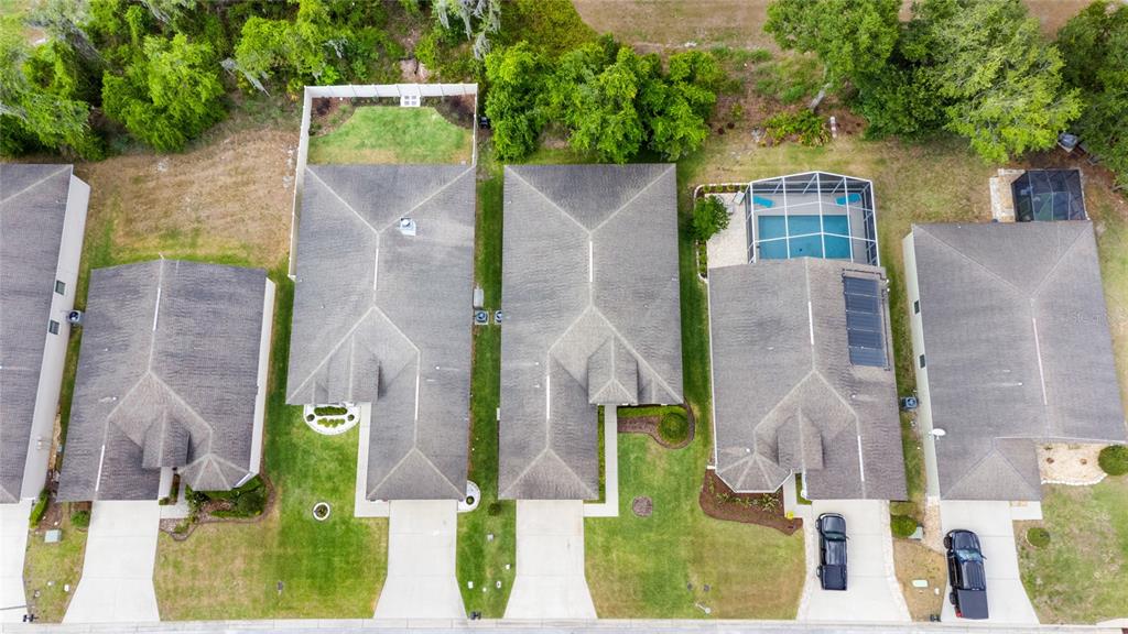 An aerial view shows four suburban houses with driveways, roofs, and a backyard swimming pool — 6246 SILVER LEAF LANE, LAKELAND, FL