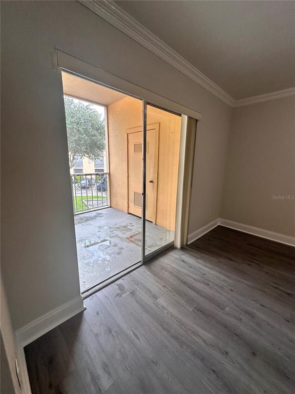 A room with wood-look flooring features a sliding glass door opening to a private balcony — 15300 SW 106TH TERRACE UNIT 520, MIAMI, FL
