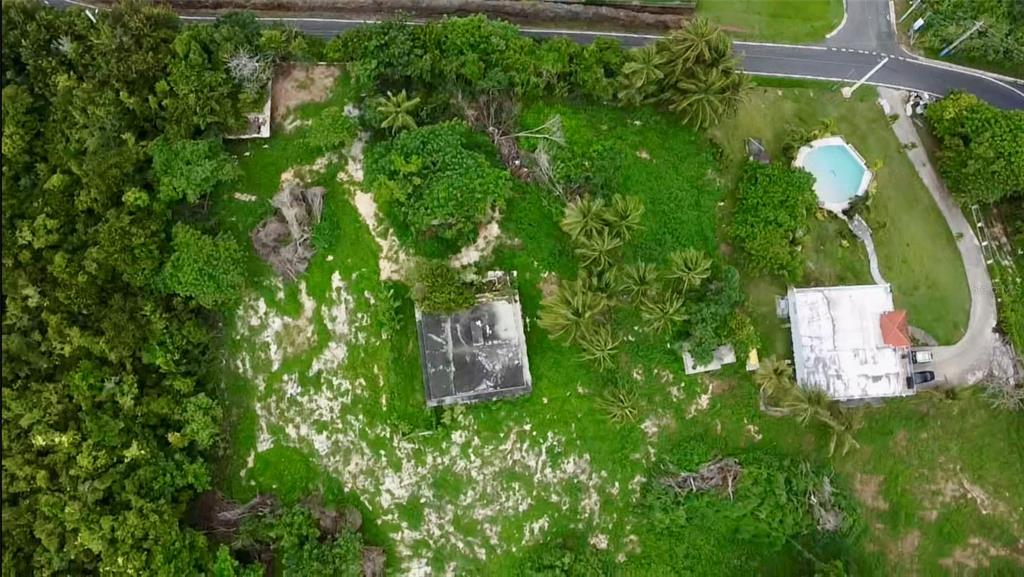 An aerial view shows a rectangular concrete foundation, a small house, and a swimming pool — PR-648 MAR CHIQUITA, MANATI, PR