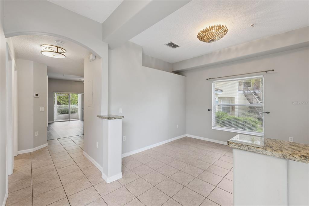 An interior view of a dining area with tile flooring, granite counters, and a window — 674 SANDY NECK LANE UNIT 104, ALTAMONTE SPRINGS, FL