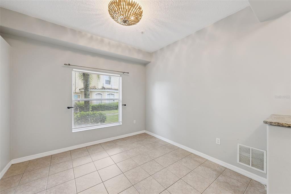 An empty room features light-colored walls, tiled flooring, a window with blinds, and a light fixture — 674 SANDY NECK LANE UNIT 104, ALTAMONTE SPRINGS, FL