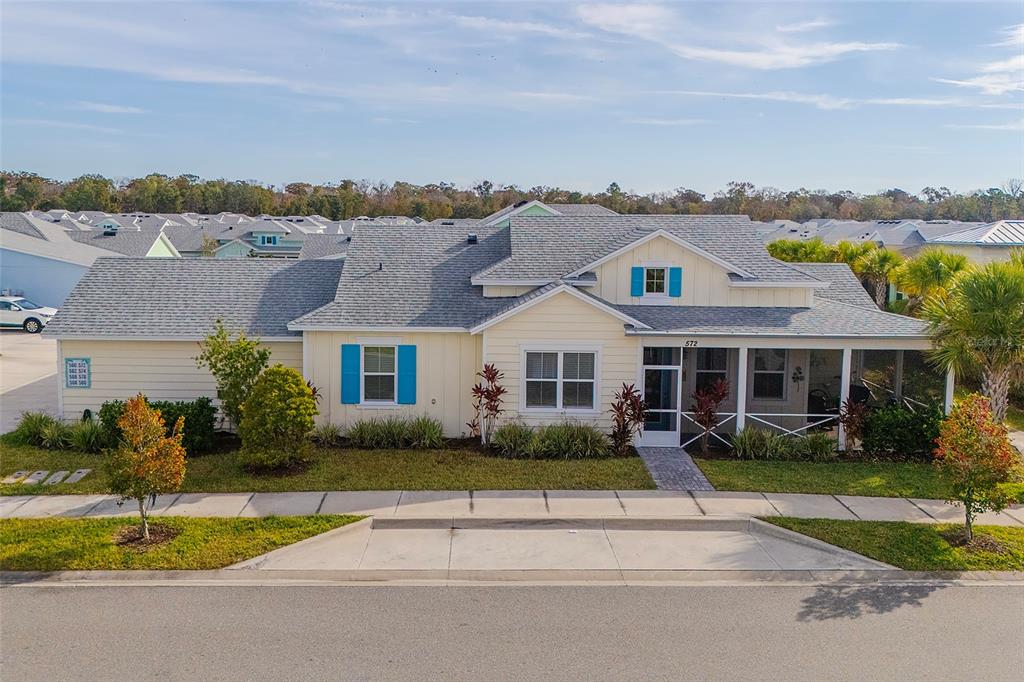 A single-story house with light yellow siding, blue shutters, and a covered front porch — 572 LANDSHARK BOULEVARD, DAYTONA BEACH, FL