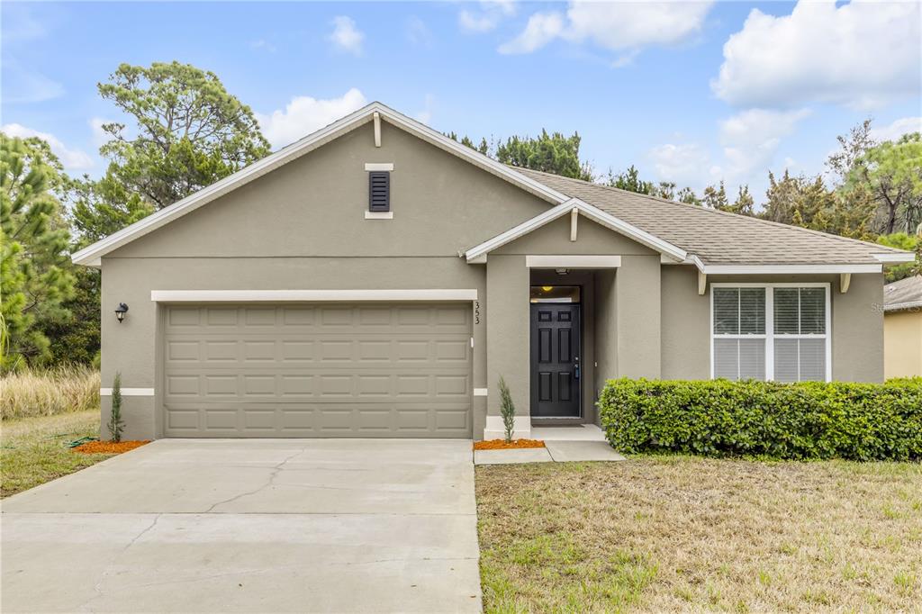 A single-story house with a beige stucco exterior, a two-car garage, and a front entrance — 353 ADMIRALTY COURT, EDGEWATER, FL