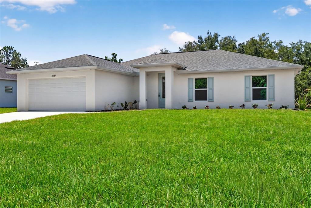 An open-concept living and dining room with wood-look flooring, neutral walls, and sliding glass doors — 18367 BUTTERCUP AVENUE, PORT CHARLOTTE, FL
