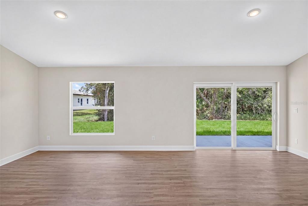 A living room features a beige sofa, a round coffee table, and a wooden media console — 18367 BUTTERCUP AVENUE, PORT CHARLOTTE, FL