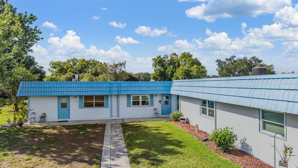 A single-story building with a blue metal roof and white exterior walls features two entrances — 302 ANDOVER PLACE S UNIT 167, SUN CITY CENTER, FL