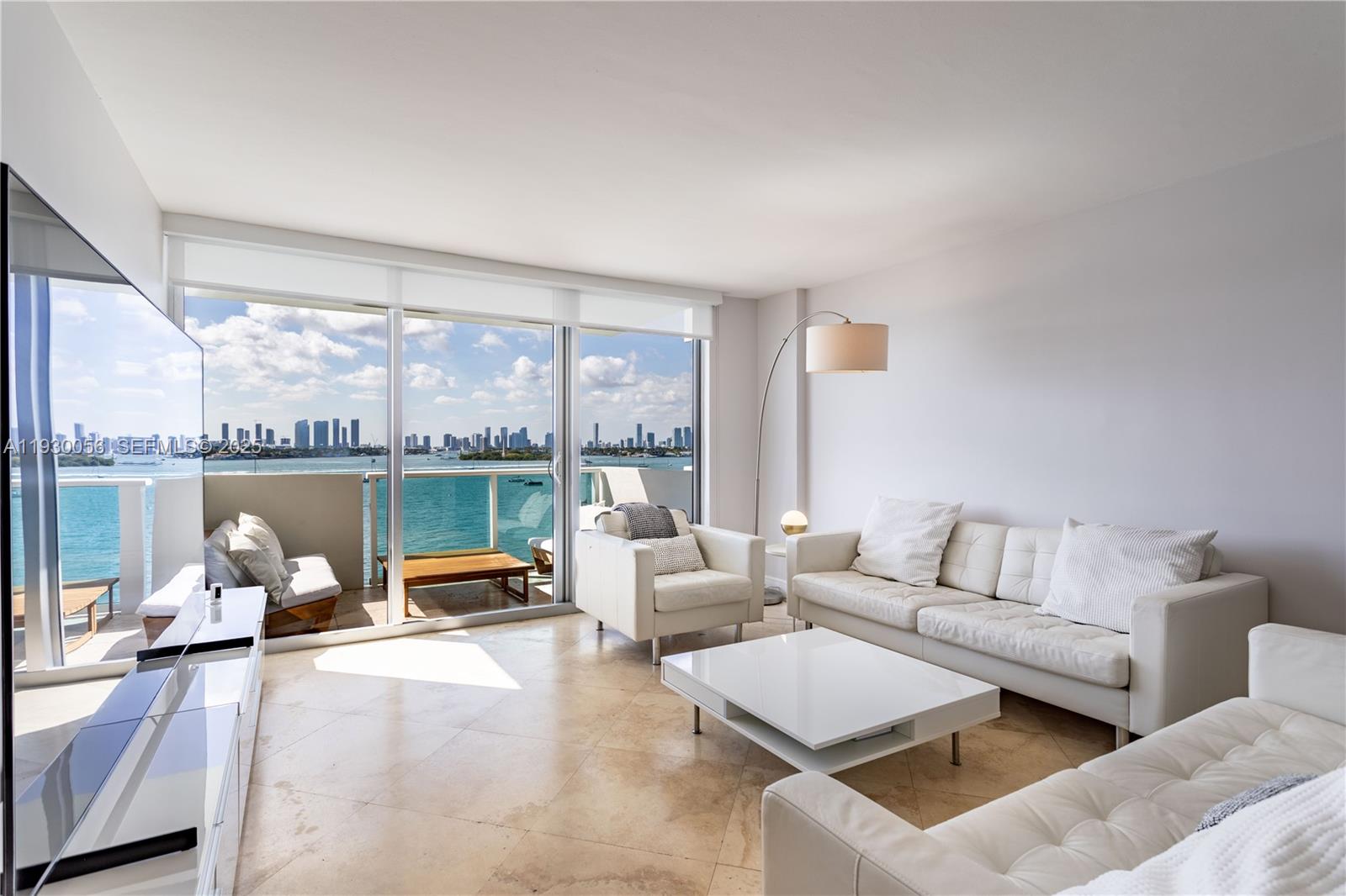 A bright living room features white furniture, tile floors, and a balcony with city views — 1200 West Ave # 526, Miami Beach FL 33139, MIAMI BEACH, FL