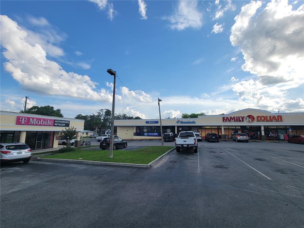 A strip mall features a T-Mobile, a Domino's, and a Family Dollar with a parking lot — 5912 SE ABSHIER BOULEVARD, BELLEVIEW, FL