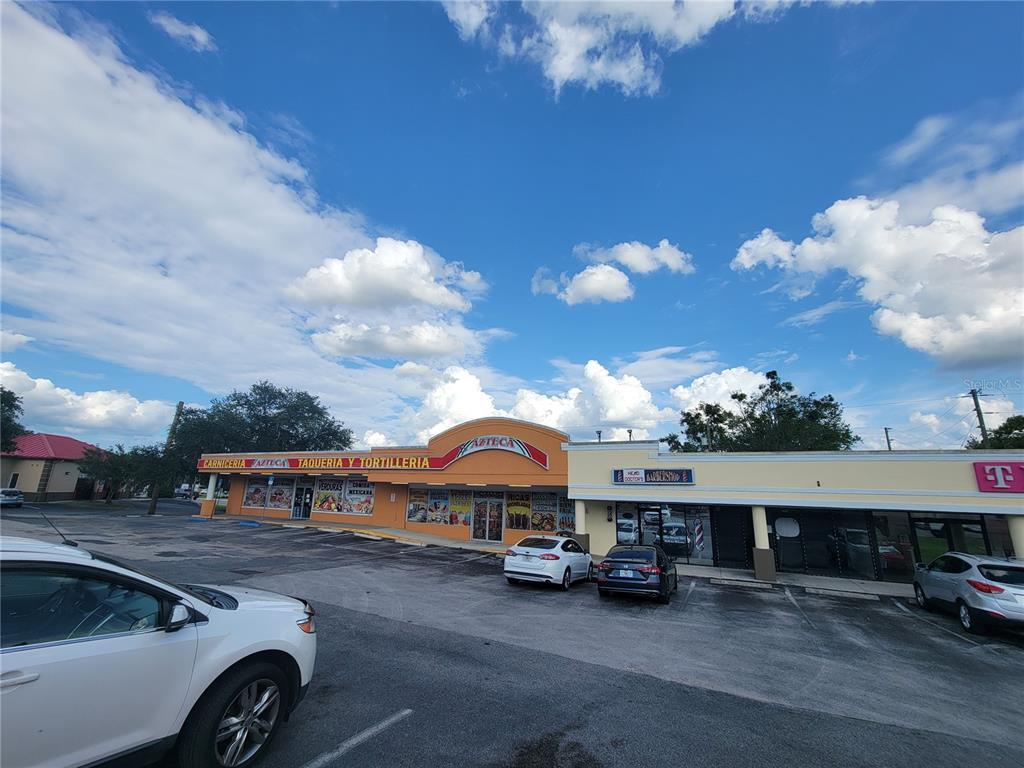 An exterior view of a commercial strip mall featuring a Mexican market and barbershop — 5912 SE ABSHIER BOULEVARD, BELLEVIEW, FL