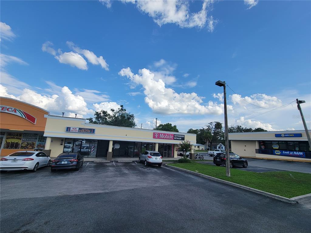 A strip mall exterior features a T-Mobile store, a barbershop, and a NAPA Auto Parts — 5912 SE ABSHIER BOULEVARD, BELLEVIEW, FL