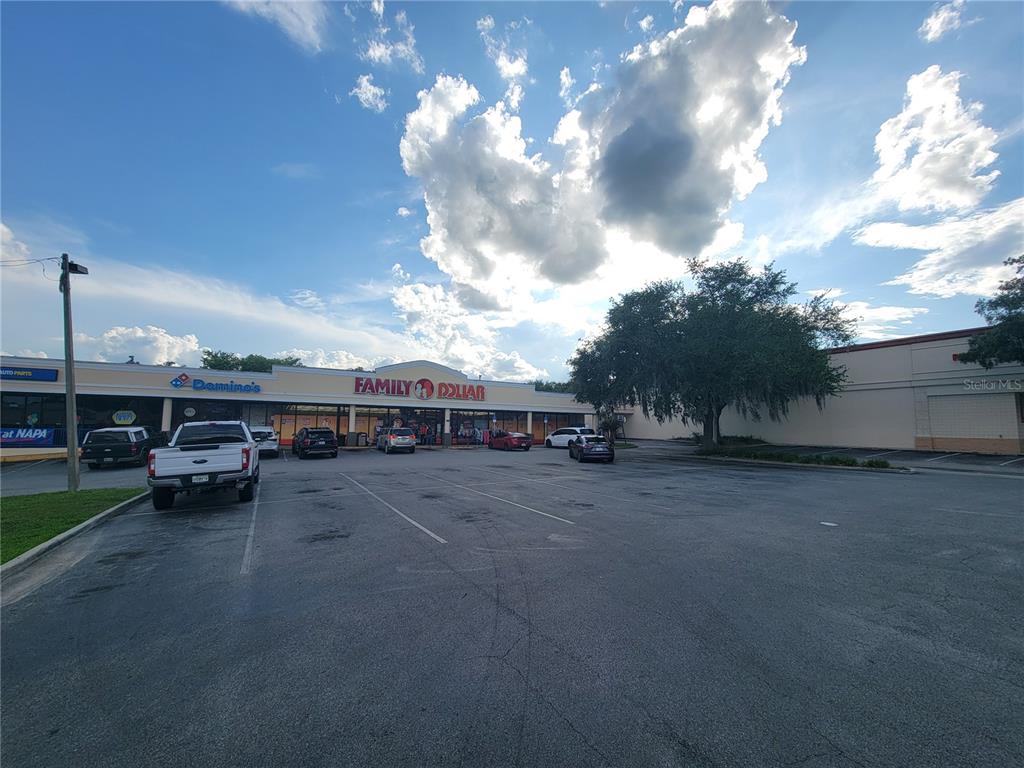 A parking lot sits in front of a strip mall featuring a Family Dollar store — 5912 SE ABSHIER BOULEVARD, BELLEVIEW, FL