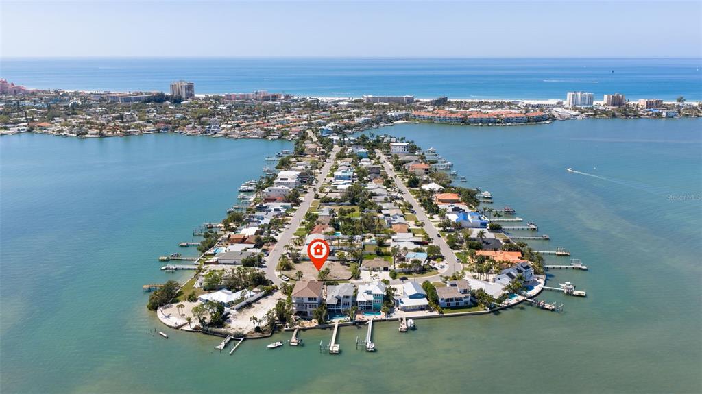 An aerial view shows a vacant waterfront lot marked with a red house icon — 911 BOCA CIEGA ISLE DRIVE, ST PETE BEACH, FL
