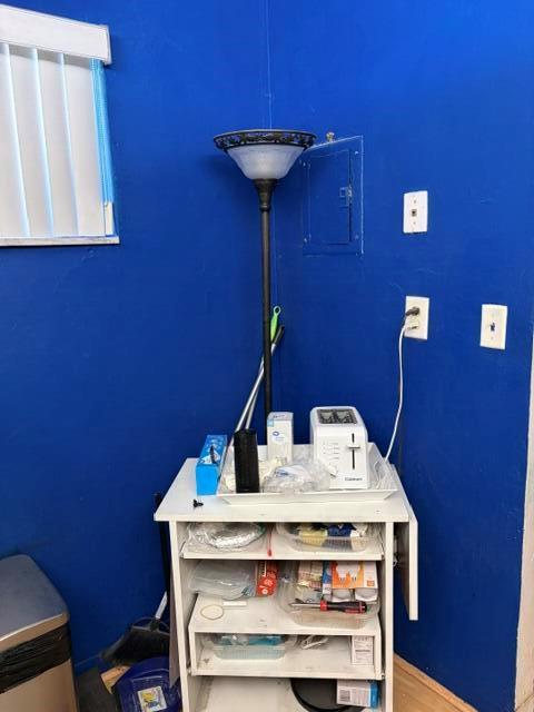 A white utility cart with a toaster and lamp sits against a bright blue wall — 2640 Garden Drive S # 103, Lake Worth FL 33461, LAKE WORTH, FL
