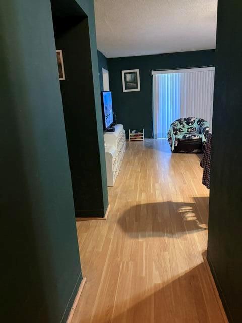 A living room features dark green walls, light wood flooring, and a patterned armchair — 2640 Garden Drive S # 103, Lake Worth FL 33461, LAKE WORTH, FL
