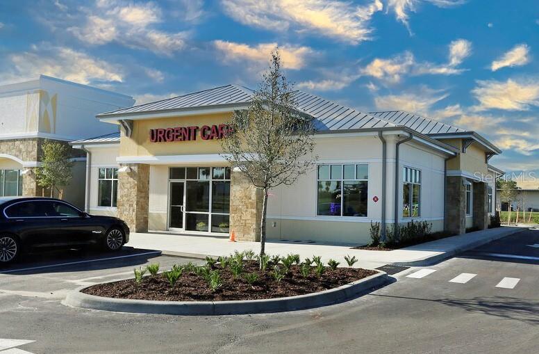 A modern, one-story urgent care building features a tan facade, stone accents, and a metal roof — 4669 E SR 44 UNIT 102/103, WILDWOOD, FL