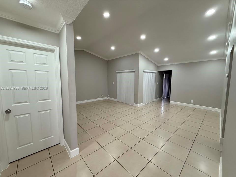 An empty room features light-colored tile flooring, recessed ceiling lights, and gray walls — 6449 NW 171st St # 0, Hialeah FL 33015, HIALEAH, FL