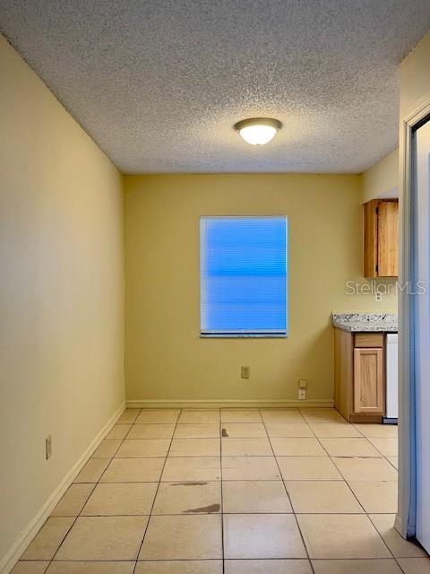 A kitchen dining area with light yellow walls, tile flooring, and a single window — 821 MARGARET STREET UNIT A, DELAND, FL