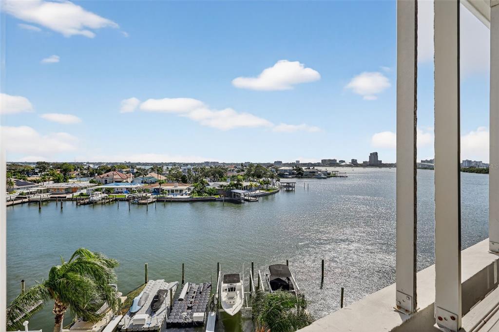 A high-angle view of a waterfront canal with private boat docks and residential homes — 31 ISLAND WAY UNIT 408, CLEARWATER BEACH, FL
