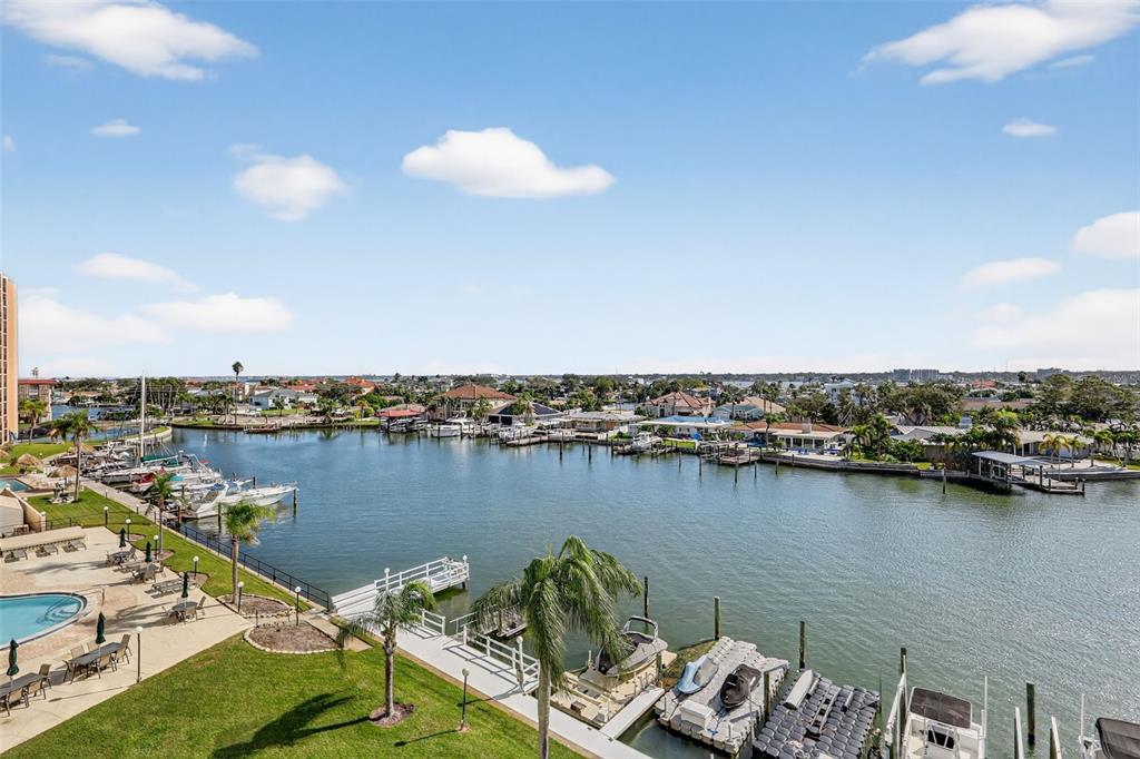 An elevated view of a canal with multiple boat docks, residential homes, and a swimming pool — 31 ISLAND WAY UNIT 408, CLEARWATER BEACH, FL