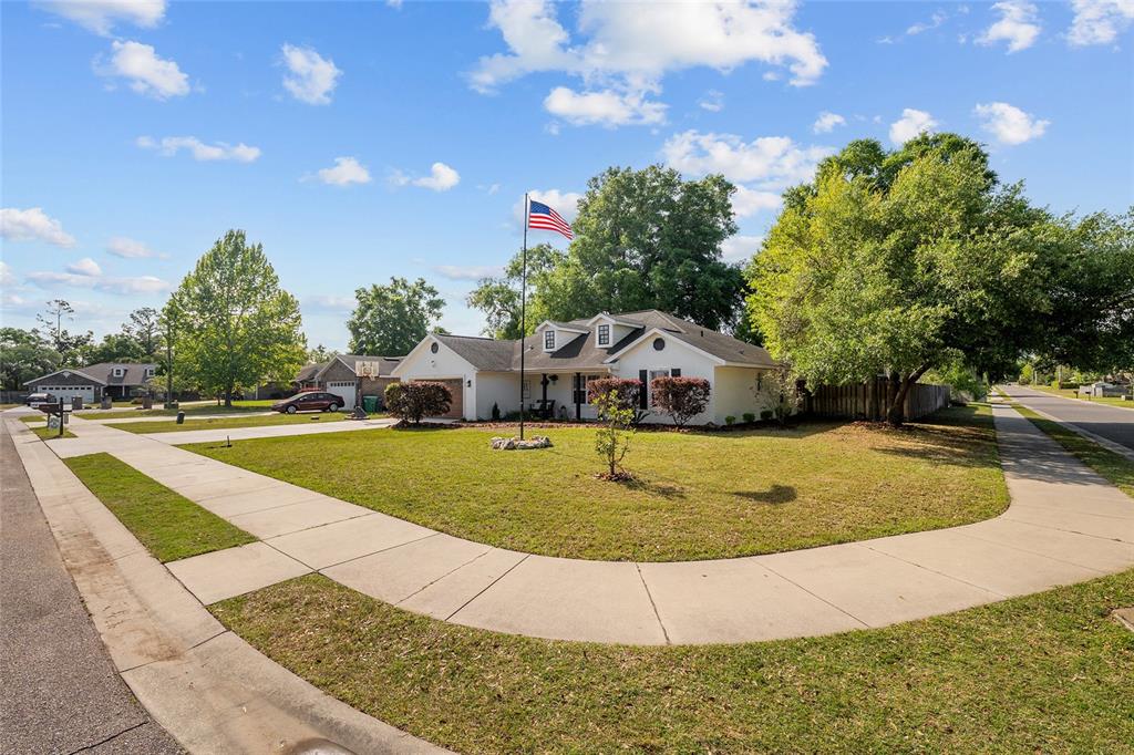 A single-story white house with a flag pole sits on a corner lot — 25175 SW 20TH AVENUE, NEWBERRY, FL