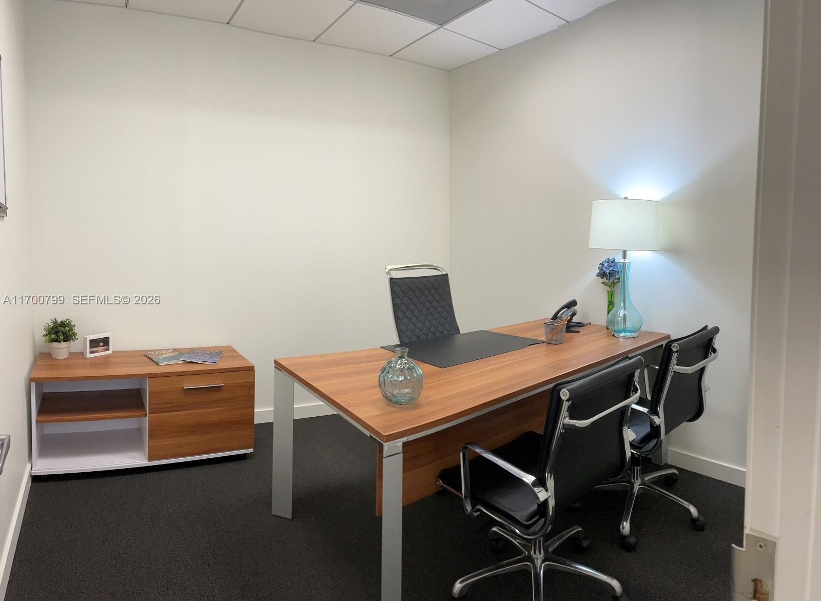 A small office features a wooden desk, two black chairs, and a matching storage cabinet — 150 SE 2nd AVE # 332, Miami FL 33131, MIAMI, FL