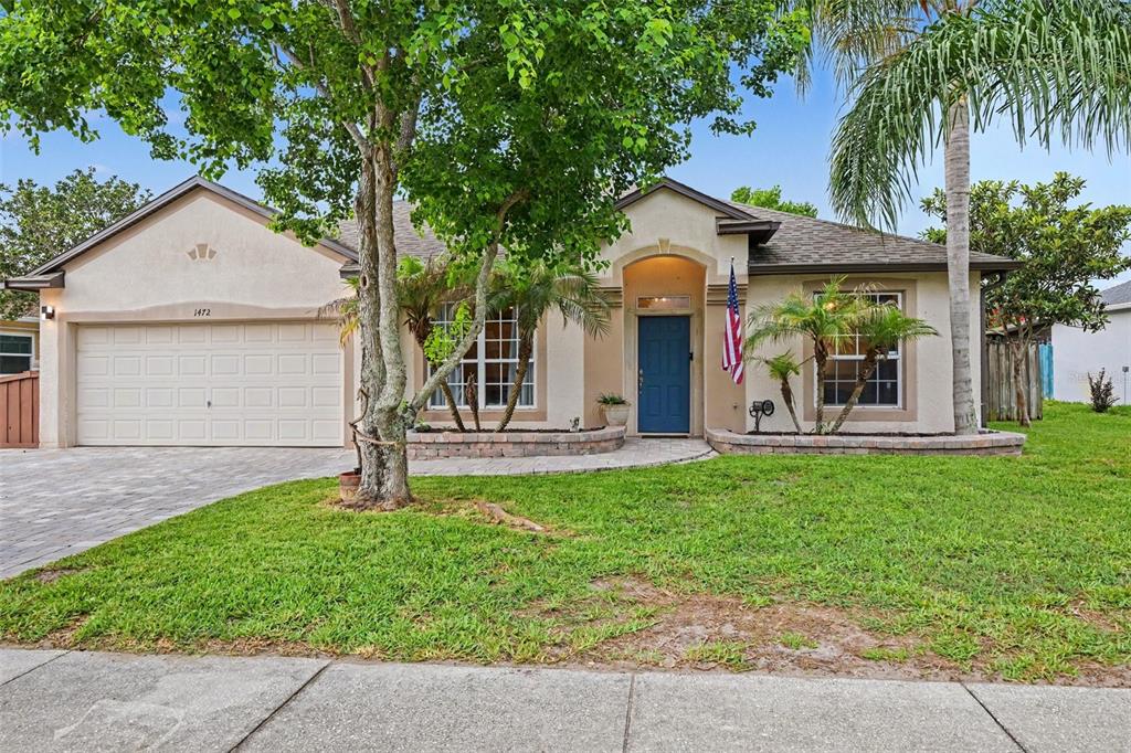 A living room features a green sofa, a large area rug, and hardwood flooring — 1472 KODAK DRIVE, TITUSVILLE, FL