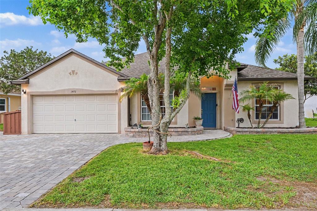 A living room features a green sofa, a white bookshelf, and a large area rug — 1472 KODAK DRIVE, TITUSVILLE, FL
