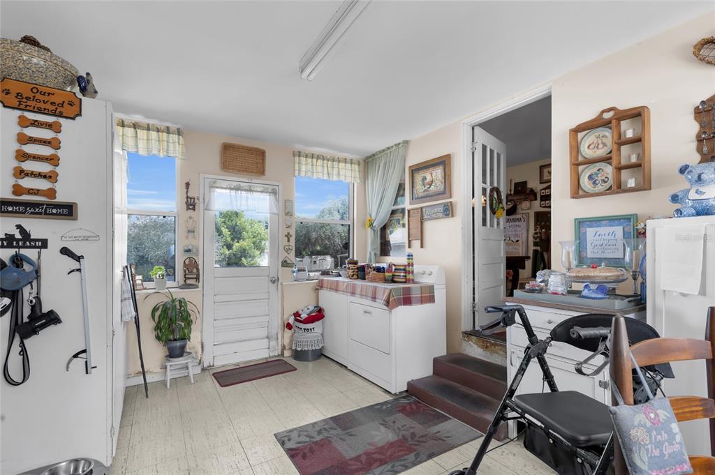 A laundry room features a white washer and dryer, a back door, and tile flooring — 5223 EAGLES NEST ROAD, FRUITLAND PARK, FL