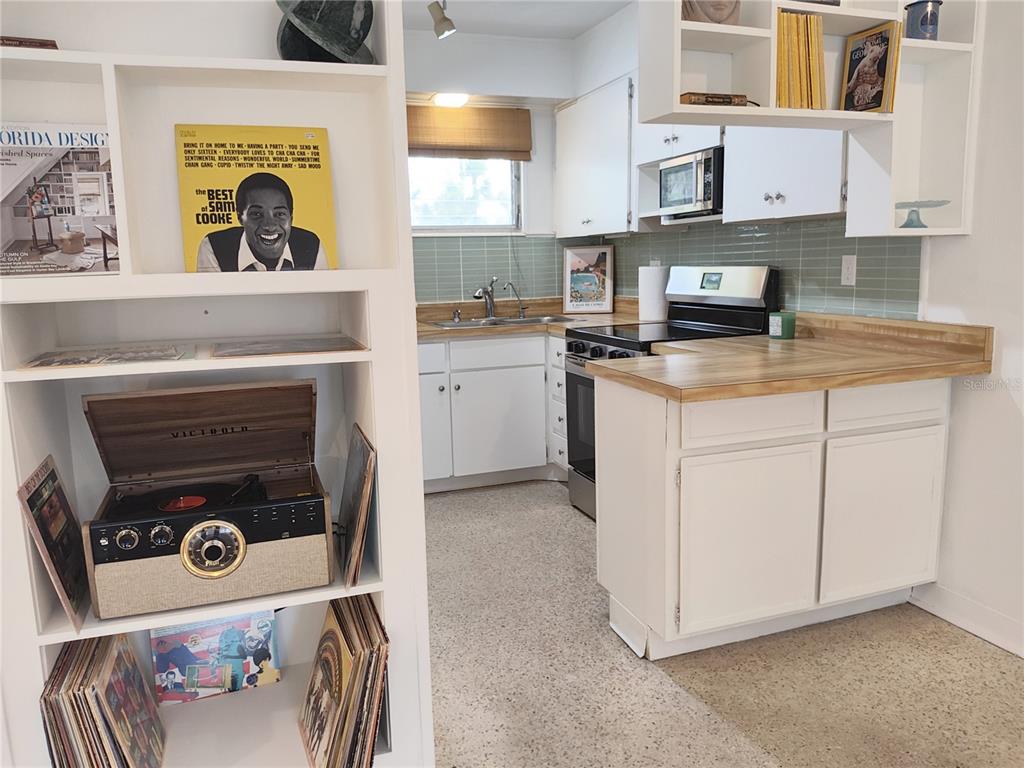 A kitchen with white cabinets, wood countertops, and a record player on a nearby shelf — 2155 WOOD STREET UNIT A26, SARASOTA, FL
