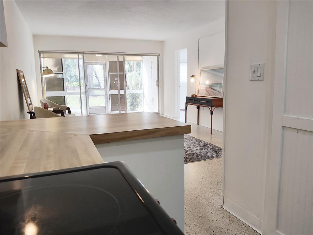 A kitchen counter overlooks a living area with a sliding glass door to a patio — 2155 WOOD STREET UNIT A26, SARASOTA, FL