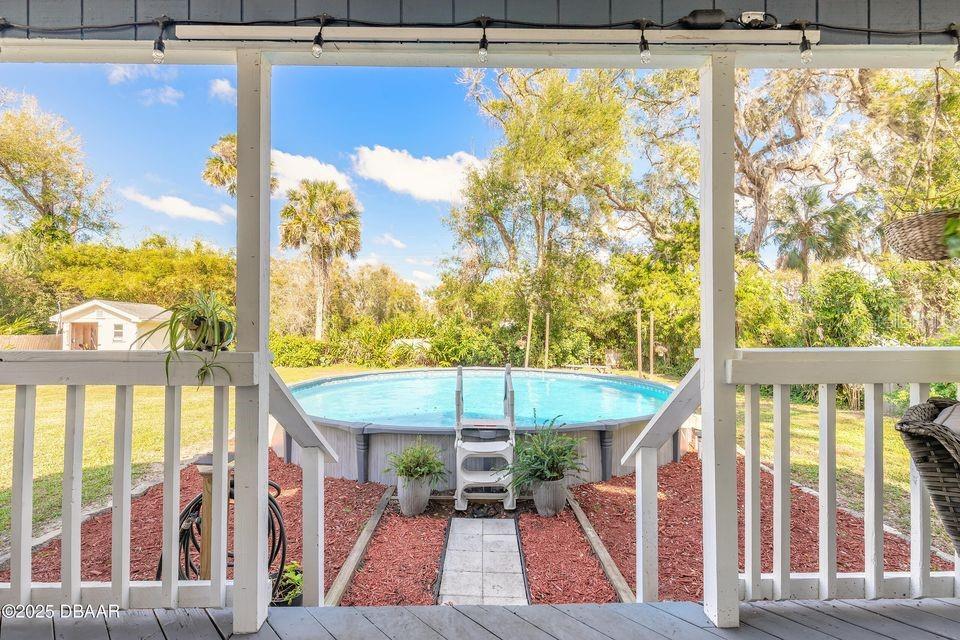 A view from a covered porch looking out toward a backyard with an above-ground pool — 1077 GEORGE ANDERSON STREET, ORMOND BEACH, FL