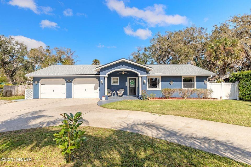A blue single-story house with a two-car garage and a covered front porch — 1077 GEORGE ANDERSON STREET, ORMOND BEACH, FL