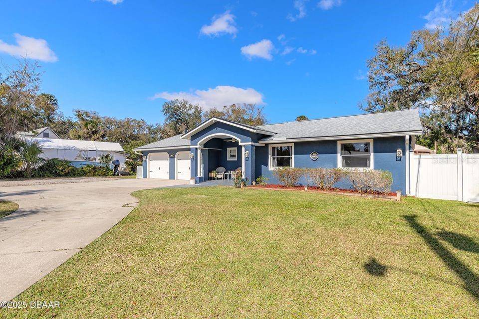 A blue single-story house with a two-car garage and a large front lawn — 1077 GEORGE ANDERSON STREET, ORMOND BEACH, FL
