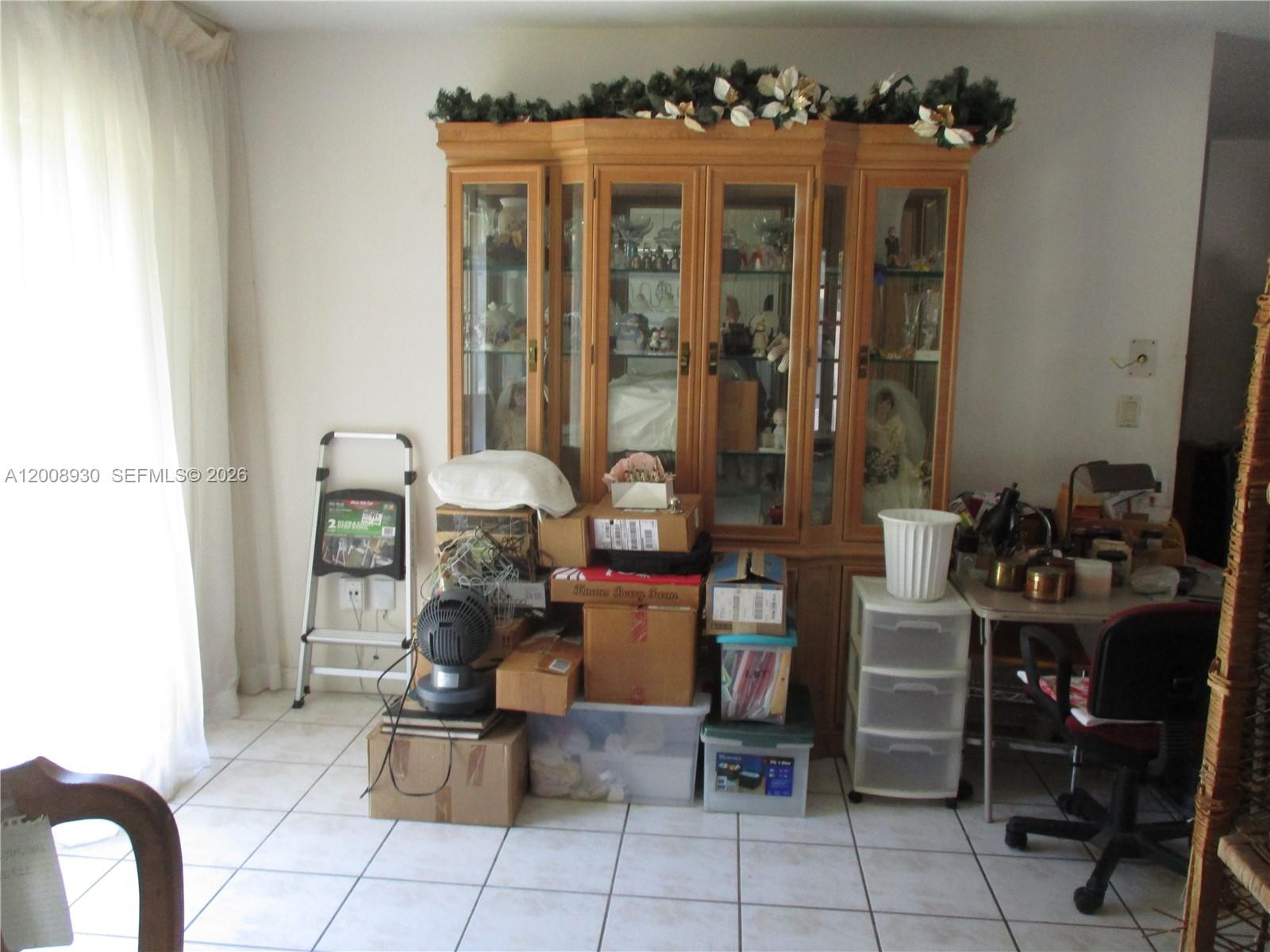 A room features a large wooden china cabinet surrounded by stacked boxes and office furniture — 19311 Gulfstream Rd, Cutler Bay FL 33157, CUTLER BAY, FL