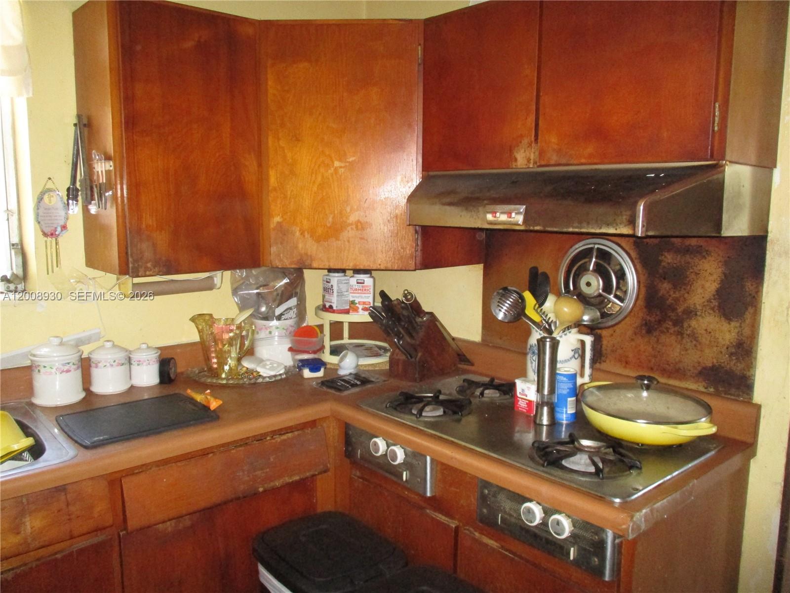 A kitchen features wood cabinets, a gas cooktop, and a metal range hood — 19311 Gulfstream Rd, Cutler Bay FL 33157, CUTLER BAY, FL