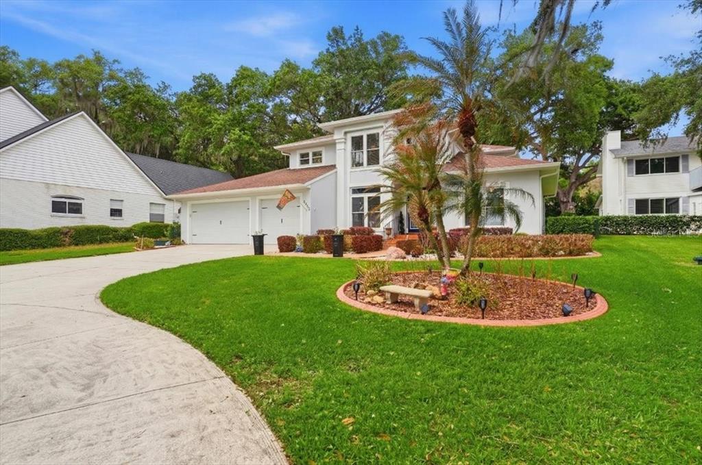 A two-story house with a two-car garage, a circular garden bed, and a concrete driveway — 2000 LAKE ARIANA BOULEVARD, AUBURNDALE, FL