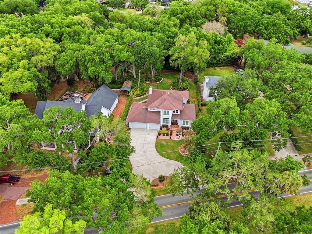 An aerial view shows a two-story house with a large driveway surrounded by dense trees — 2000 LAKE ARIANA BOULEVARD, AUBURNDALE, FL
