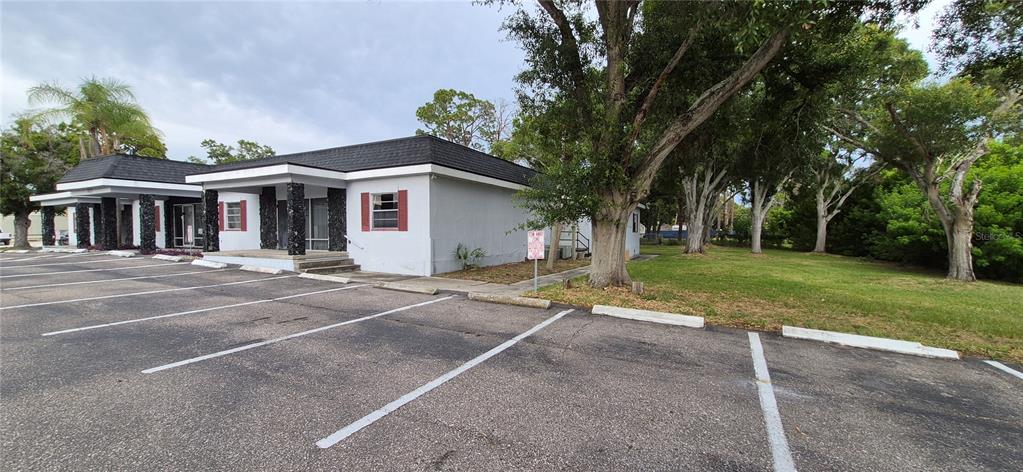 A single-story commercial building with a black roof and a paved parking lot in front — 7789 131ST STREET N, SEMINOLE, FL