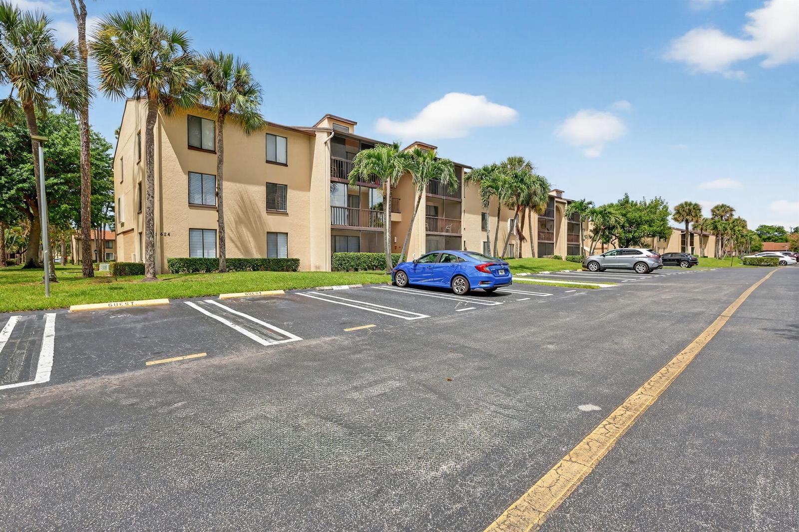 A multi-story apartment building with tan stucco walls sits behind a paved parking lot — 624 Sea Pine Way # B3, FL 33415, FL