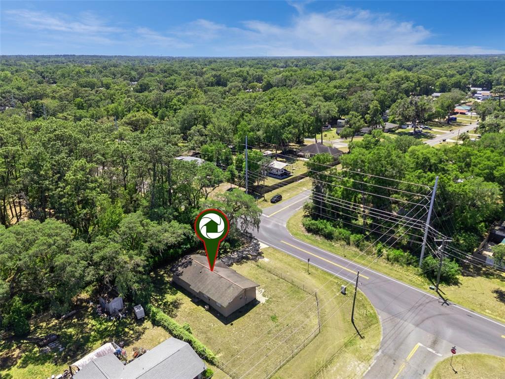 An aerial view shows a single-story house situated on a corner lot near trees — 4225 NE 25TH AVENUE, OCALA, FL