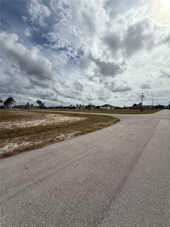 An empty, grassy residential lot sits at the corner of two paved roads — 2801 NW 45TH PLACE, CAPE CORAL, FL