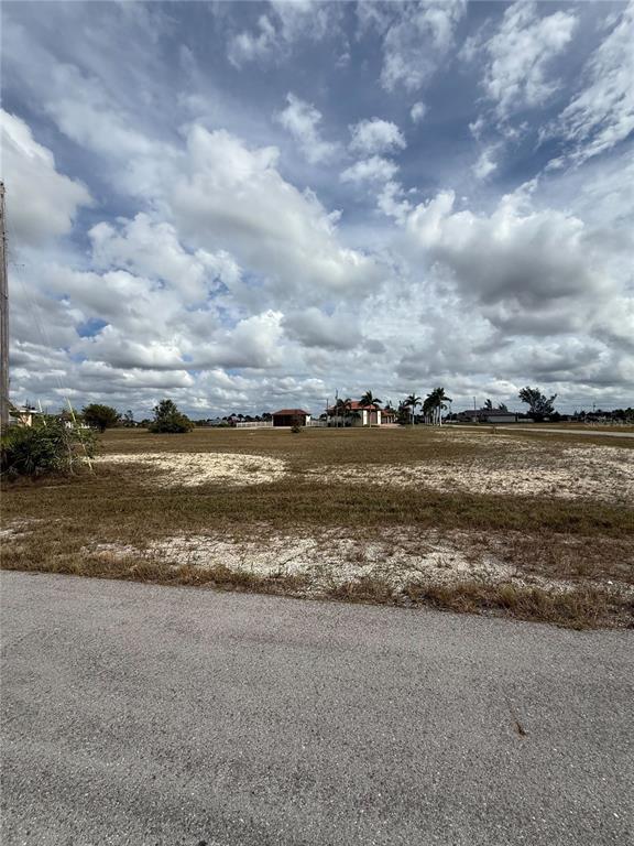 A vacant, grassy lot with patches of sand sits along a paved road — 2801 NW 45TH PLACE, CAPE CORAL, FL
